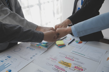 A group of businesspeople and investors meet to discuss market's success in past quarter. idea of setting up a marketing consulting team and working together as a team made it a success.の写真素材