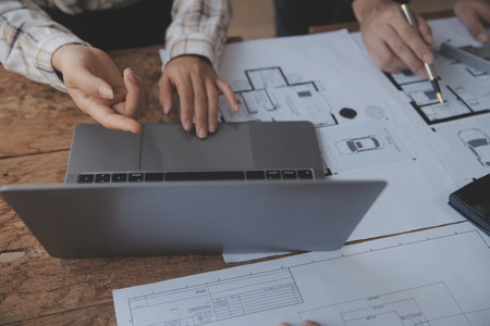 Construction and structure concept of engineer working drawing on blueprint meeting for project working with partner on model building and engineering tools in working site, construction concept.の写真素材