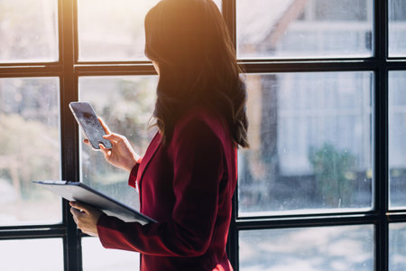 Entrepreneur Asian businessman and businesswoman discussing new business project in tablet in modern Meeting In Modern Office, Asian business casual concept.の写真素材