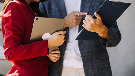 Entrepreneur Asian businessman and businesswoman discussing new business project in tablet in modern Meeting In Modern Office, Asian business casual concept.の写真素材