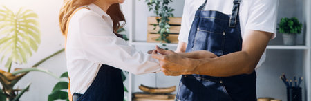 Happy young adult couple making breakfast and drinking coffee together in cozy home kitchen in morning at home. Preparing meal and smiling. Lifestyle, leisure and Love concept.の写真素材