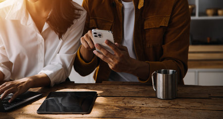 Entrepreneur Asian businessman and businesswoman discussing new business project in tablet in modern Meeting In Modern Office, Asian business casual concept.の写真素材