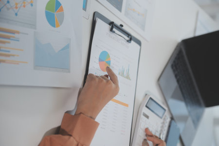 Businesswoman or accountant working Financial investment on calculator, calculate, analyze business and marketing growth on financial document data graph, Accounting, Economic, commercial concept.の写真素材