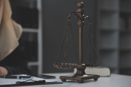 Business and lawyers discussing contract papers with brass scale on desk in office. Law, legal services, advice, justice and law concept picture with film grain effectの写真素材