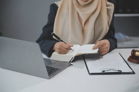 Business and lawyers discussing contract papers with brass scale on desk in office. Law, legal services, advice, justice and law concept picture with film grain effectの写真素材