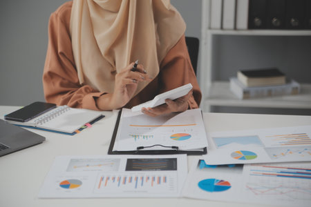 Businesswoman or accountant working Financial investment on calculator, calculate, analyze business and marketing growth on financial document data graph, Accounting, Economic, commercial concept.の写真素材