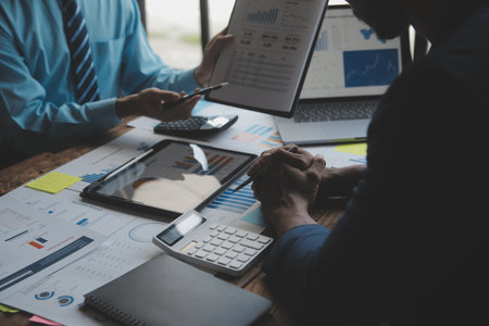 Financial analysts analyze business financial reports on a digital tablet planning investment...