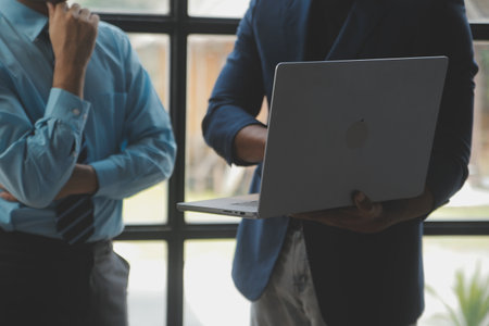 Financial analysts analyze business financial reports on a digital tablet planning investment project during a discussion at a meeting of corporate showing the results of their successful teamwork.の写真素材