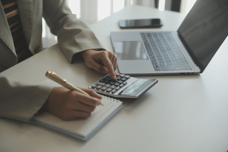 Businesswoman or accountant working Financial investment on calculator, calculate, analyze business and marketing growth on financial document data graph, Accounting, Economic, commercial concept.の写真素材