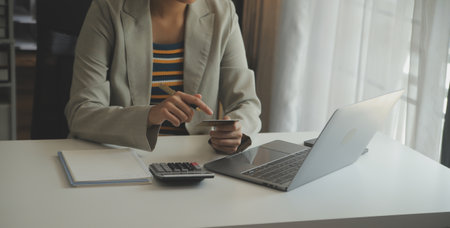 Close up woman hand using credit card and smartphone laptop for buying online shoppingの写真素材