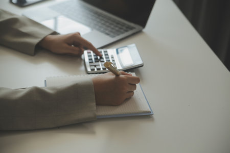 Businesswoman or accountant working Financial investment on calculator, calculate, analyze business and marketing growth on financial document data graph, Accounting, Economic, commercial concept.の写真素材