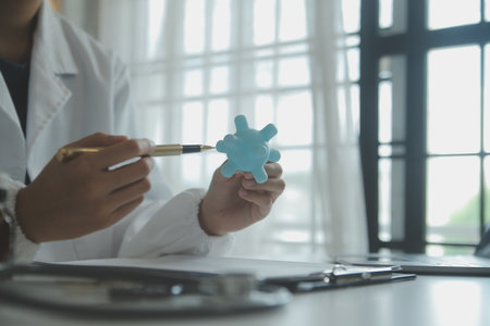 Doctor and patient sitting and talking at medical examination at hospital office, close-up. Therapist filling up medication history records. Medicine and healthcare concept.の写真素材