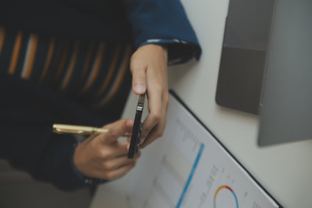 Entrepreneur Asian businessman and businesswoman discussing new business project in tablet in modern Meeting In Modern Office, Asian business casual concept.の写真素材