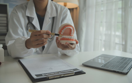 Dentists are discussing dental problems at report x-ray image on laptop screen to patients.の写真素材