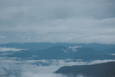 Mountain range with visible silhouettes through the morning blue fog.の写真素材