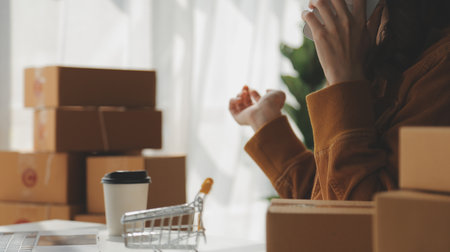 Portrait young attractive hipster asia female owner startup look at camera work happy with box at home prepare parcel delivery in sme supply chain, procurement, omnichannel ecommerce online concept.の写真素材