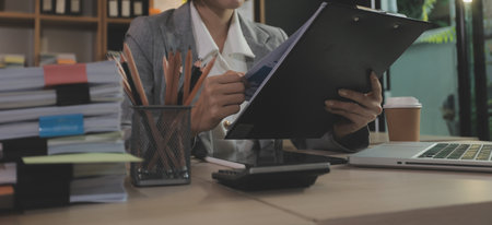 Entrepreneur Asian businessman and businesswoman discussing new business project in tablet in modern Meeting In Modern Office, Asian business casual concept.の写真素材