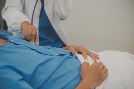 Close up of Female Doctor using stethoscope putting beat heart diagnose with patient in examination room at a hospital, check-up body, Medical and Health Care Concept.の写真素材