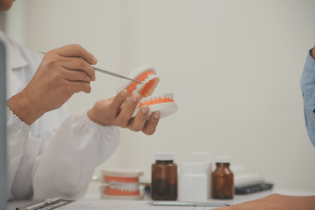 Dentists are discussing dental problems at report x-ray image on laptop screen to patients.の写真素材
