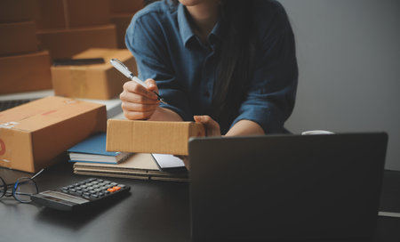 Business woman start up small business entrepreneur SME success .freelance woman working at home with Online Parcel delivery. SME and packaging deliveryconceptの写真素材