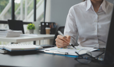Entrepreneur Asian businessman and businesswoman discussing new business project in tablet in modern Meeting In Modern Office, Asian business casual concept.の写真素材