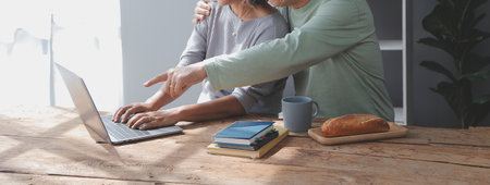 Asian mature senior couple look talk to smartphone camera at home. video calling communicate in...