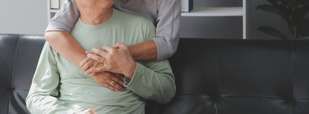 Asian mature senior couple look talk to smartphone camera at home. video calling communicate in online chatの写真素材