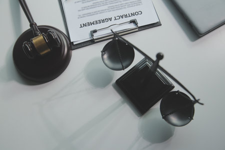 Business and lawyers discussing contract papers with brass scale on desk in office. Law, legal services, advice, justice and law concept picture with film grain effectの写真素材
