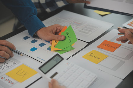 Close up ux developer and ui designer brainstorming about mobile app interface wireframe design on...
