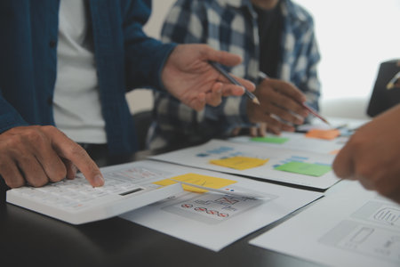 Close up ux developer and ui designer brainstorming about mobile app interface wireframe design on...