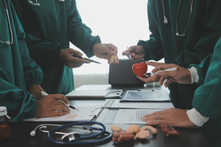 Multiracial team of doctors discussing a patient standing grouped in the foyer looking at a tablet computer, close up viewの写真素材