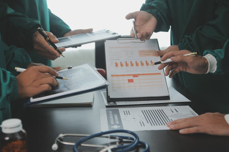 Multiracial team of doctors discussing a patient standing grouped in the foyer looking at a tablet computer, close up viewの写真素材
