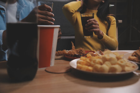 fat woman bite piece of pizza,overweight female is eating fast foods,asian girl is hungryの写真素材