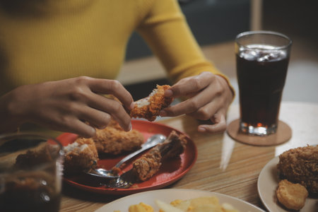 fat woman bite piece of pizza,overweight female is eating fast foods,asian girl is hungryの写真素材