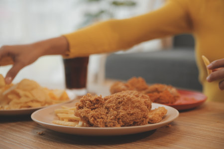 fat woman bite piece of pizza,overweight female is eating fast foods,asian girl is hungryの写真素材