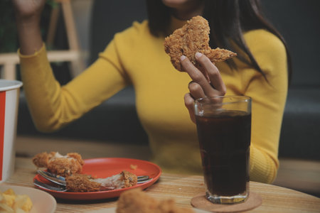 fat woman bite piece of pizza,overweight female is eating fast foods,asian girl is hungryの写真素材