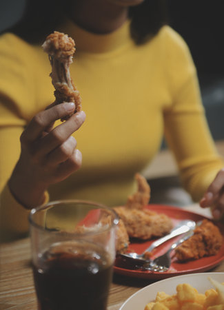fat woman bite piece of pizza,overweight female is eating fast foods,asian girl is hungryの写真素材