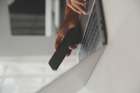 Asian Businesswoman Using laptop computer and working at office with calculator document on desk, doing planning analyzing the financial report, business plan investment, finance analysis concept.の写真素材