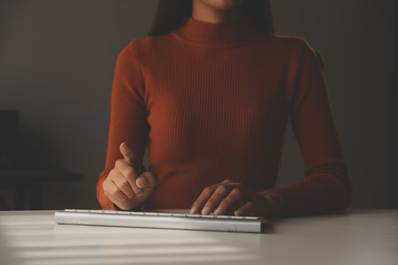 Asian Businesswoman Using laptop computer and working at office with calculator document on desk, doing planning analyzing the financial report, business plan investment, finance analysis concept.の写真素材