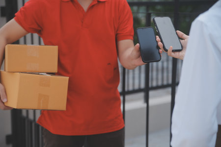 Asian Woman Receiving Product from delivery man at Home, Young Owner Woman Order Product from Smartphone Application, Woman with Online Business or SME Concept.の写真素材