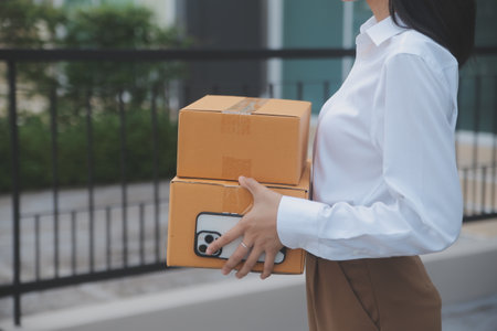 Asian Woman Receiving Product from delivery man at Home, Young Owner Woman Order Product from Smartphone Application, Woman with Online Business or SME Concept.の写真素材