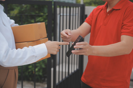 Asian Woman Receiving Product from delivery man at Home, Young Owner Woman Order Product from Smartphone Application, Woman with Online Business or SME Concept.の写真素材