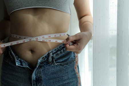 Close up of a belly with scar from c-section and abdominal fat. Women's health. A woman dressed up...