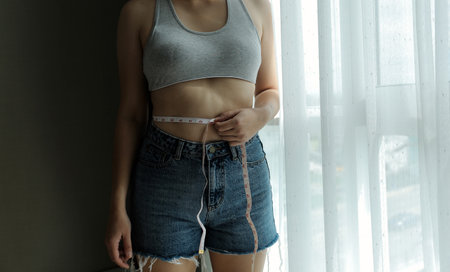 Close up of a belly with scar from c-section and abdominal fat. Women's health. A woman dressed up...
