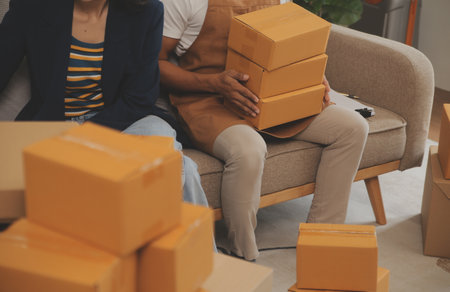 Startup small business owner working with computer at workplace. Freelance two woman seller check product order. Packing goods for delivery to customer. Online selling. E-commerce. Online Shoppingの写真素材