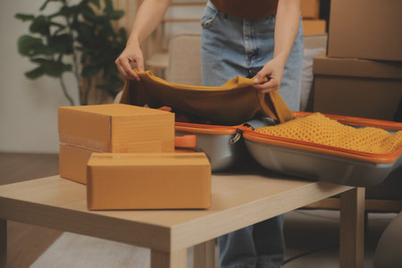 Beautiful young couple in love having fun unpacking things from cardboard boxes while moving in together in their new apartmentの写真素材