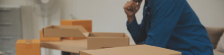 Beautiful young couple in love having fun unpacking things from cardboard boxes while moving in...
