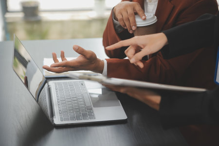 Financial analysts analyze business financial reports on a digital tablet planning investment project during a discussion at a meeting of corporate showing the results of their successful teamwork.の写真素材