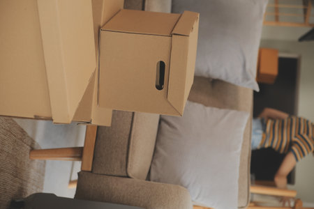 Beautiful young couple in love having fun unpacking things from cardboard boxes while moving in together in their new apartmentの写真素材