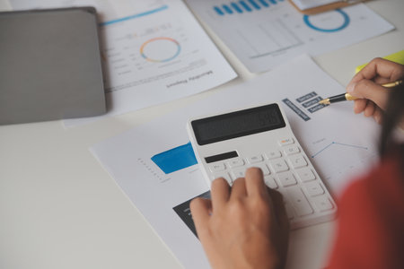 Close up Business woman using calculator and laptop for do math finance on wooden desk, tax, accounting, statistics and analytical research conceptの写真素材